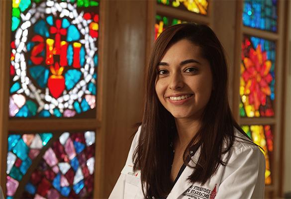 Medical student in front of stained glass window 